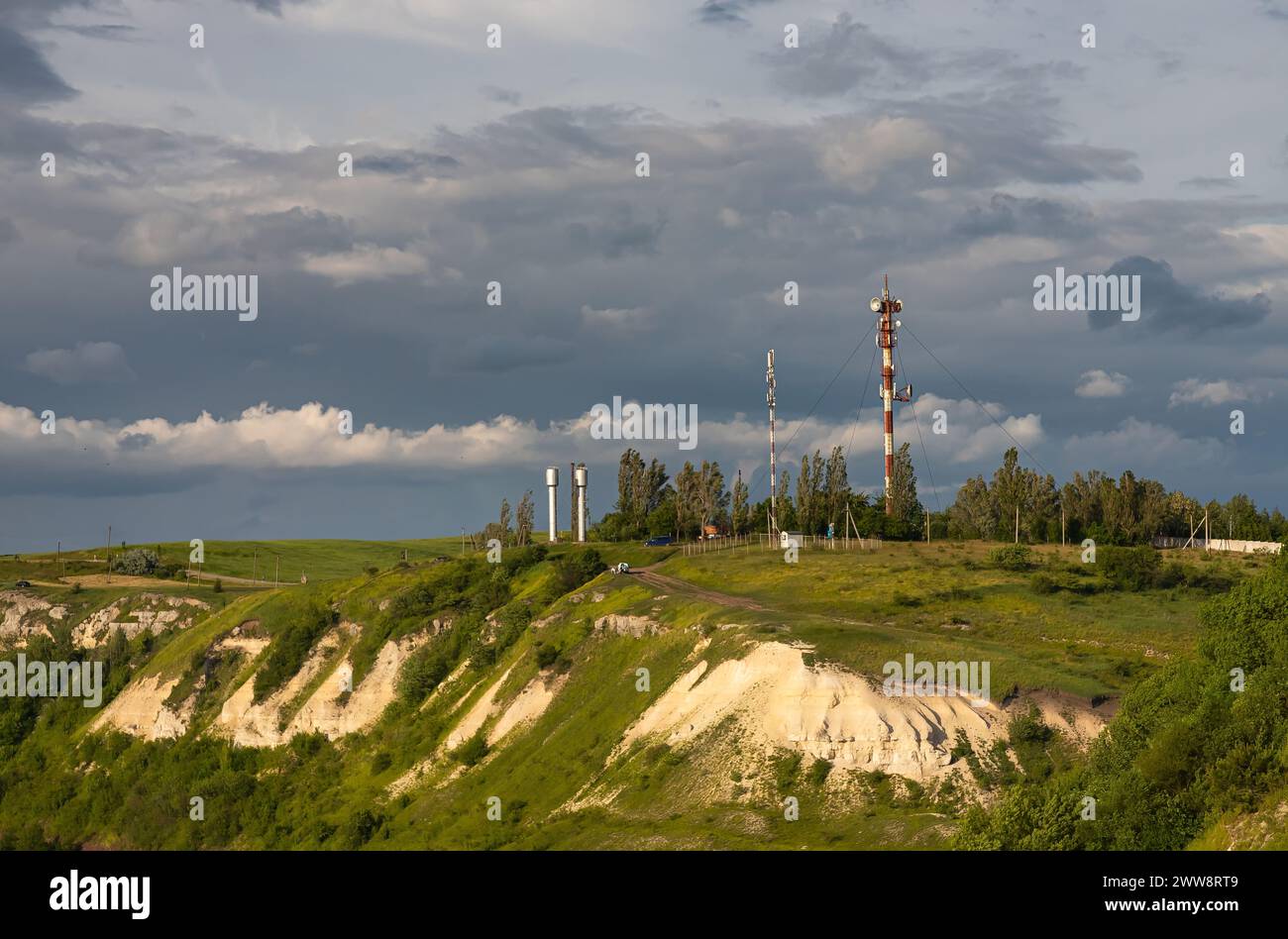 Torre della televisione, torre del telefono cellulare sopra la campagna sullo sfondo del cielo con nuvole Foto Stock