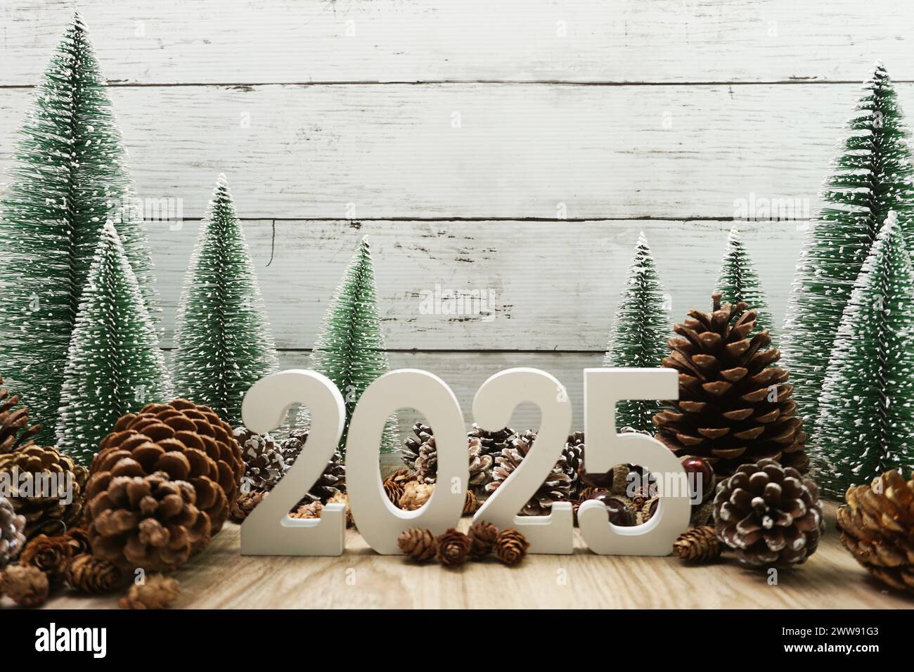 Felice anno nuovo 2025 decorazione con albero di Natale e coni di pino su sfondo in legno Foto Stock