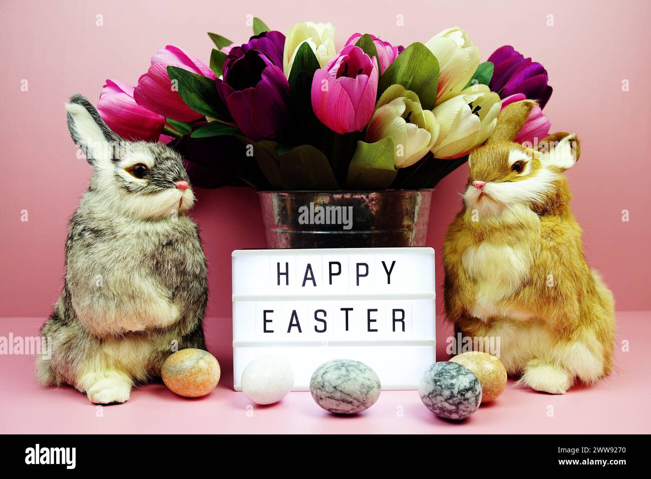 Scatola luminosa di buona Pasqua con decorazione degli elementi pasquali su sfondo rosa Foto Stock