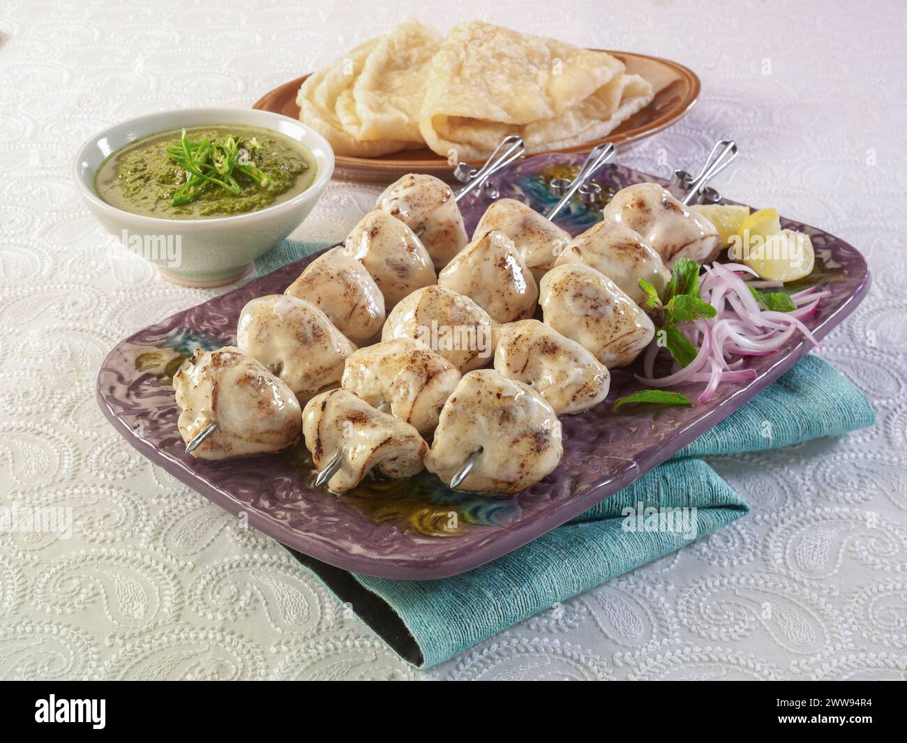 Pollo Malai Boti o Chicken Cream Marinated Kabab è un piatto unico e delizioso barbecue. Serve con salsa al peperoncino verde e paratha caldo. Foto Stock