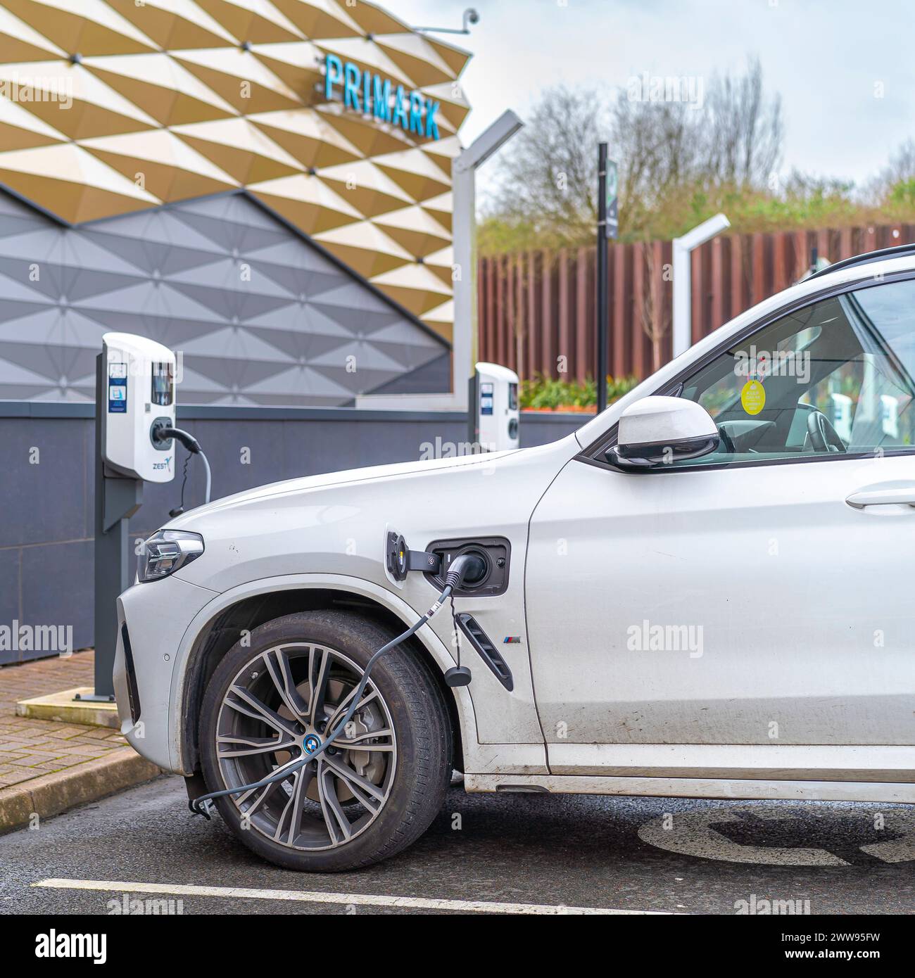 Primo piano del punto di ricarica per auto elettriche utilizzato dall'auto dell'acquirente all'esterno del negozio Primark presso il centro commerciale Merry Hill nelle Midlands, Regno Unito. Foto Stock