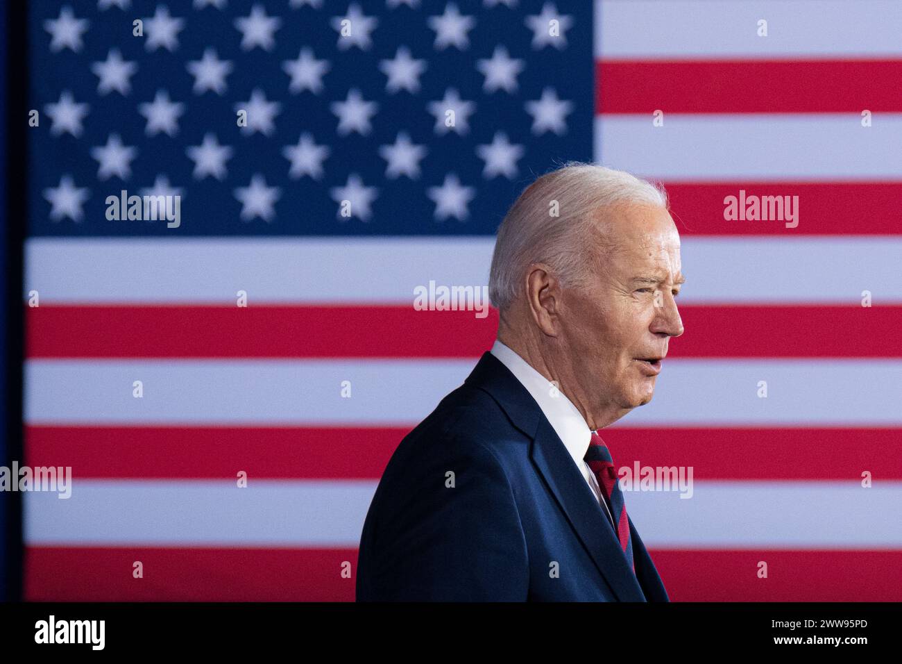 Il presidente Joe Biden parla a una folla con un grande sfondo di bandiera americana, a Milwaukee, Wisconsin, USA, mercoledì, 13 marzo 2024. Foto Stock