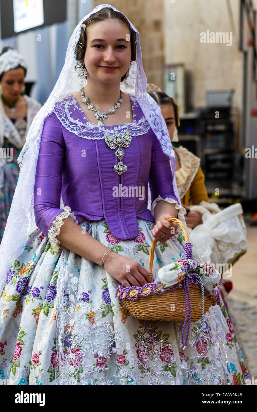 Fallas Festival a Gandia Spagna Una celebrazione della cultura. Donna in abbigliamento tradizionale con cesto di fiori incarna lo spirito festivo di Valencia. Foto Stock