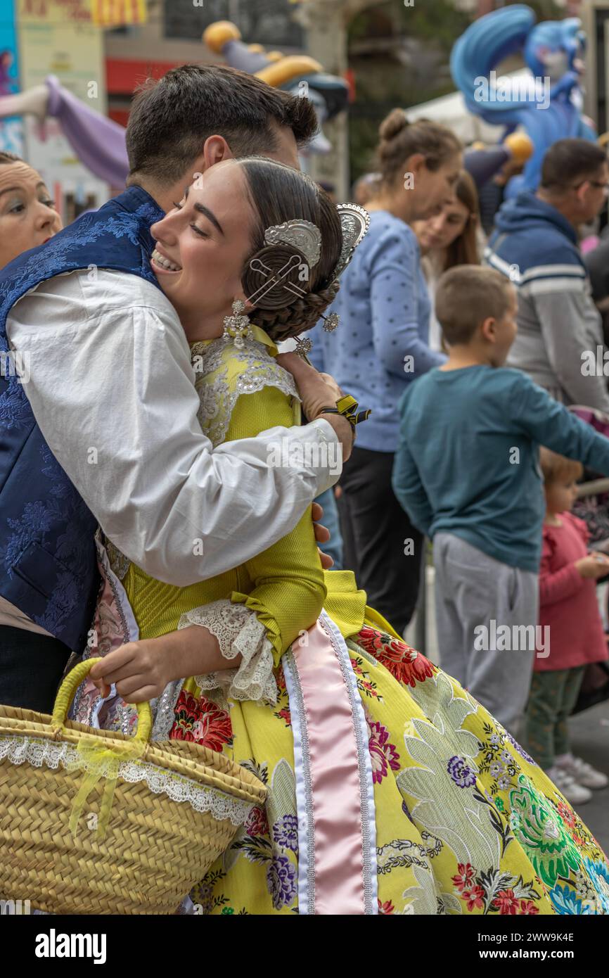 Il Fallas Festival di Gandia in Spagna cattura un momento tenero. Due persone in abbigliamento tradizionale condividono un momento di affetto in mezzo alle vivaci celebrazioni Foto Stock