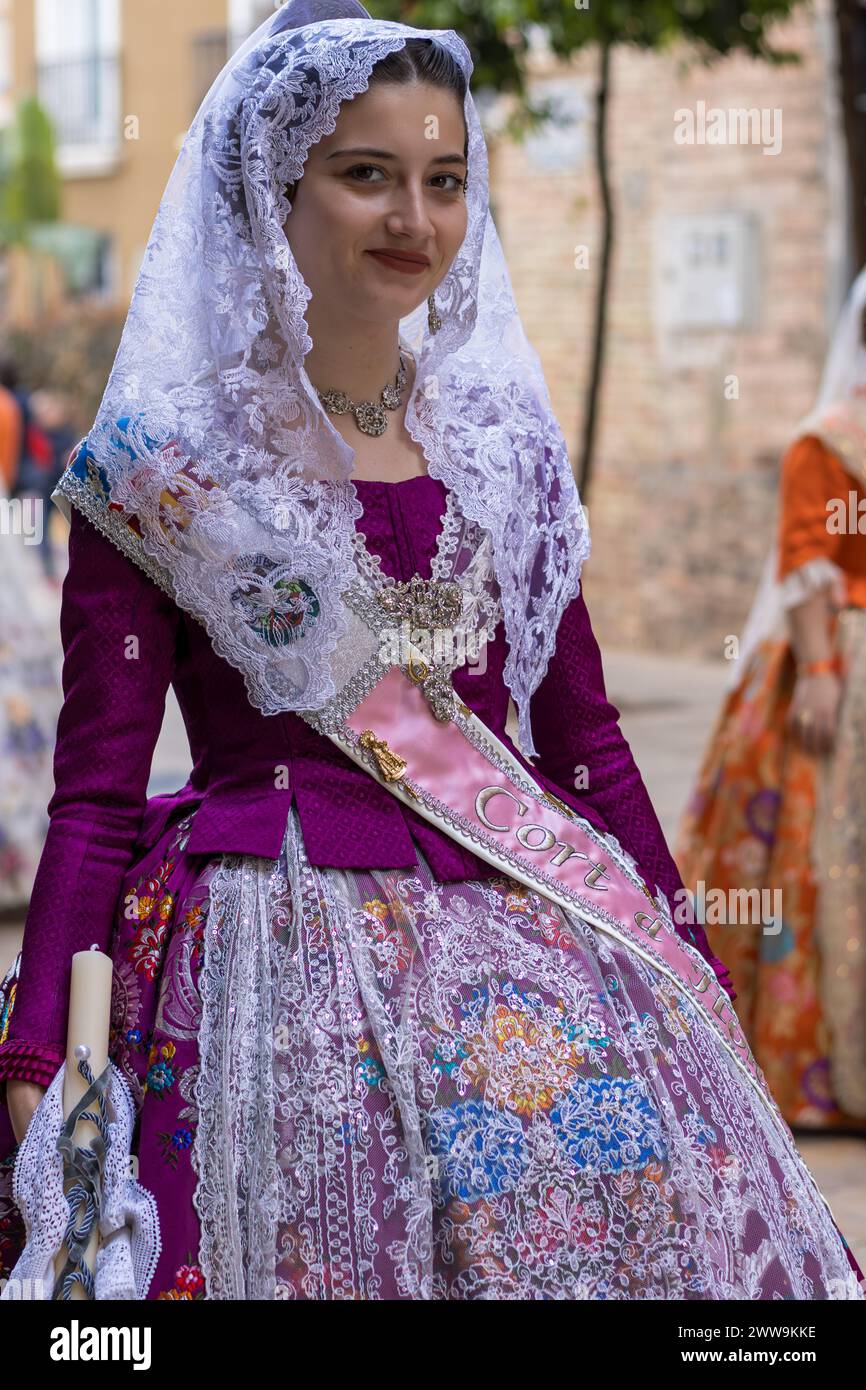 La tradizione valenciana in Vivid display, il costume Fallas di una donna irradia lo spirito festivo di Gandia. Il suo abbigliamento, intrecciato con storia e celebrazione, Foto Stock