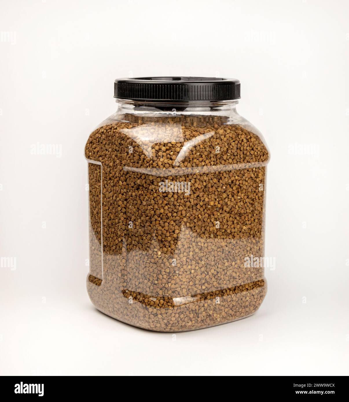 Semole di grano saraceno, in un contenitore per la conservazione dei cereali. Contenitore in plastica con grano saraceno. Foto Stock