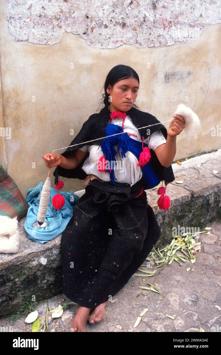 Lunedì 20 dicembre 1976, nel villaggio di San Juan Chamula, incastonato negli altipiani centrali del Chiapas nel Messico meridionale, una donna Maya Tzotzil, in abito tradizionale, impiega un classico mandrino a goccia di balena per trasformare la lana in filato, un passo importante nella creazione dell'abbigliamento che si intreccia sul suo tradizionale telaio posteriore. Foto Stock
