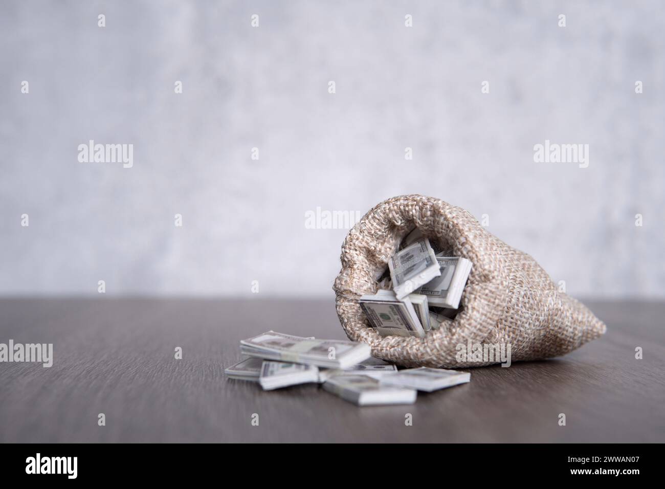 Immagine ravvicinata di un sacco di bavaglino che si sovrappone a pile di banconote in dollari USA con spazio di copia. Prosperità, ricchezza, profitto. Foto Stock