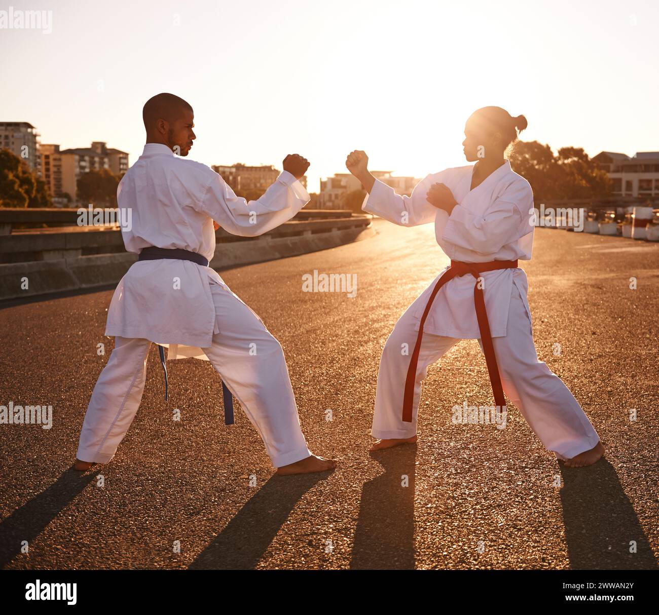 Persone, karate e lotta con personal trainer per autodifesa, tecnica o stile in città. Uomo e donna combattente o atleta in forma fisica Foto Stock