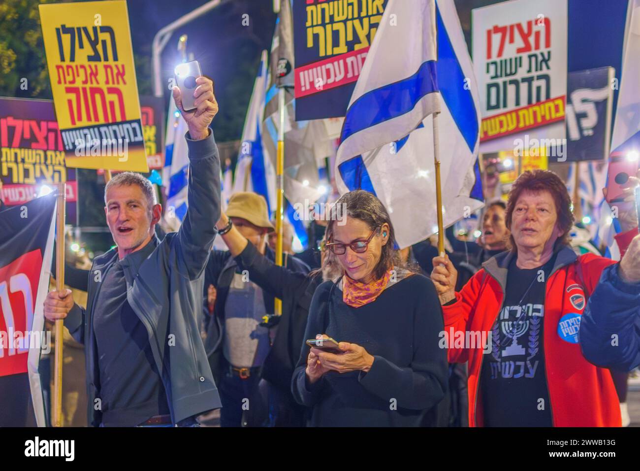 Haifa, Israele - 16 marzo 2024: Le persone prendono parte a una marcia di protesta, con vari segni e bandiere, contro il governo, che chiede nuove elezioni. Foto Stock