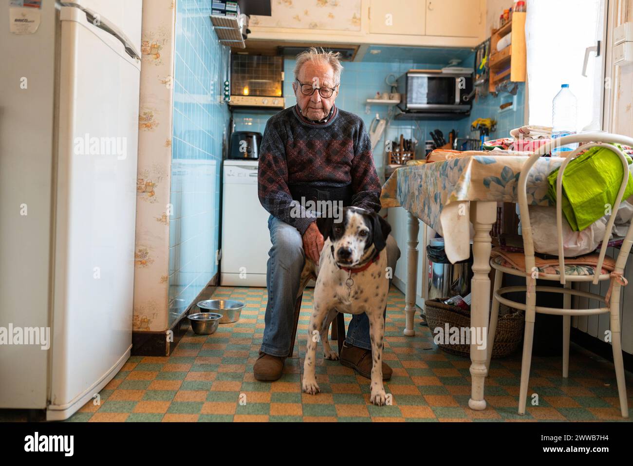 Solitudine della persona anziana, anziana che vive da sola con il proprio cane nella loro cucina. Foto Stock