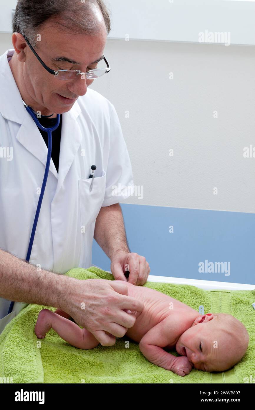Durante l'esame neurologico, il pediatra controlla i riflessi arcaici del neonato, qui l'inclinazione laterale del tronco. Foto Stock