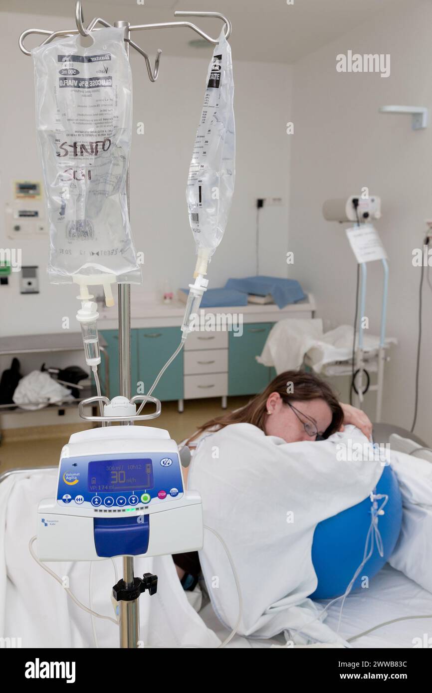 Infusione di ossitocina / sintocinone che accelera le contrazioni. Il travaglio in sala parto può talvolta durare diverse ore. Foto Stock