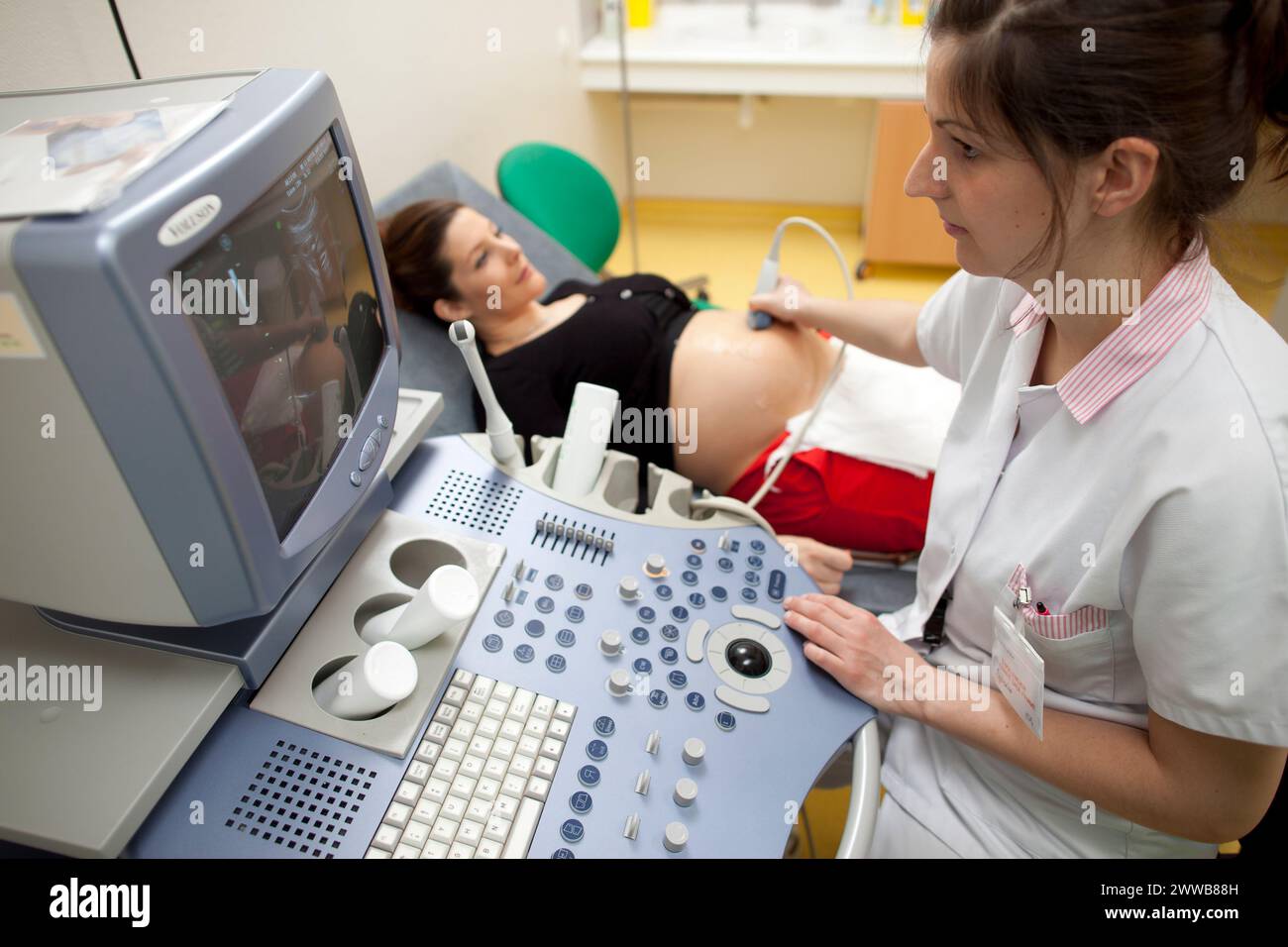 Ospedale. Maternità. ostetrica studentesca del quarto anno che esegue un'ecografia prenatale sotto la supervisione di un'ostetrica. 24 settimane, 6 mesi di gravidanza. Foto Stock