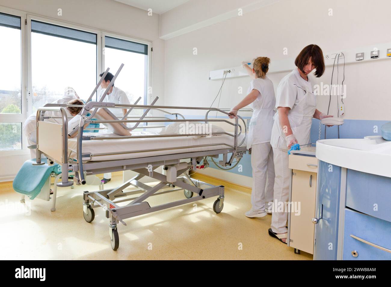 Assistenti di assistenza all'infanzia che puliscono una stanza dopo che un paziente lascia la suite di pannolini. Foto Stock