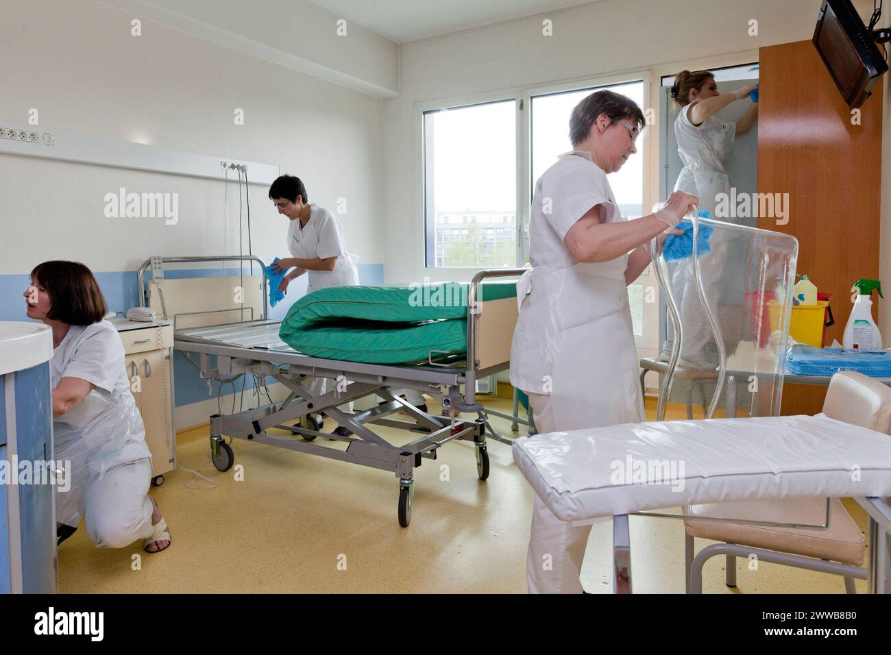 Assistenti di assistenza all'infanzia che puliscono una stanza dopo che un paziente lascia la suite di pannolini. Foto Stock