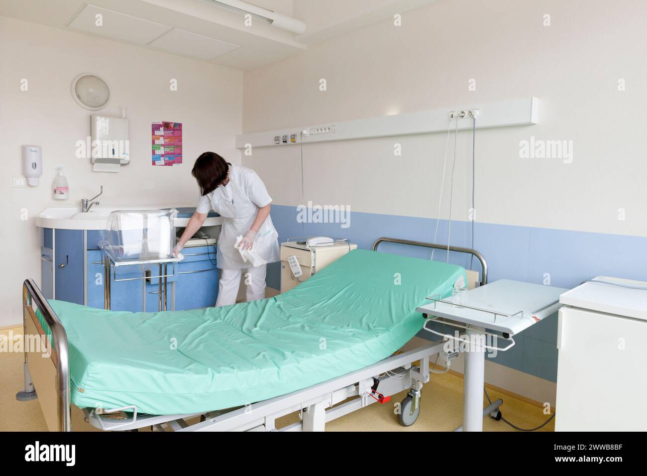 Assistenti di assistenza all'infanzia che puliscono una stanza dopo che un paziente lascia la suite di pannolini. Foto Stock