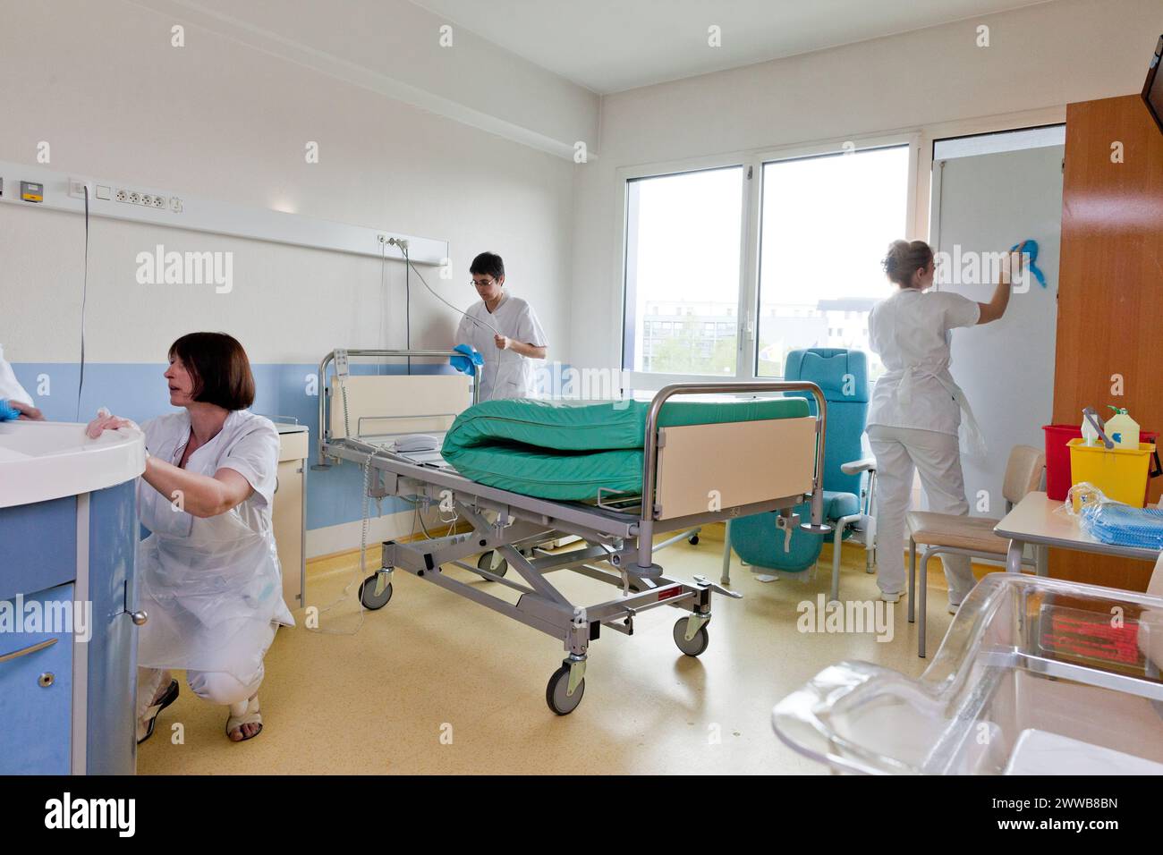 Assistenti di assistenza all'infanzia che puliscono una stanza dopo che un paziente lascia la suite di pannolini. Foto Stock