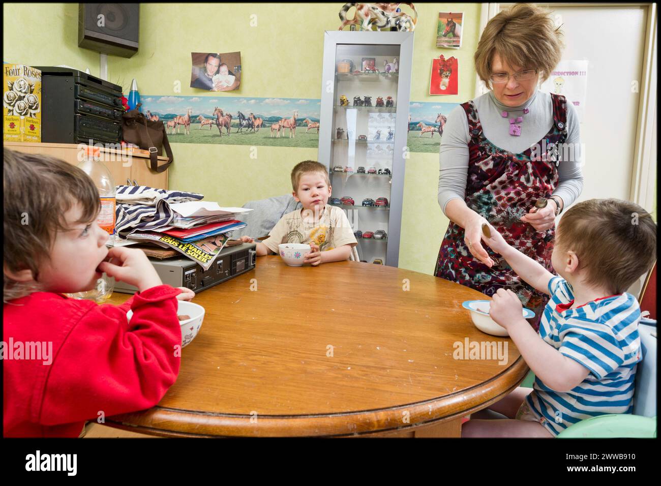 ASE - assistenza sociale infantile. Isabelle si prende cura dei bambini in modo che facciano colazione a tavola. SOLO PER USO EDITORIALE. Foto Stock