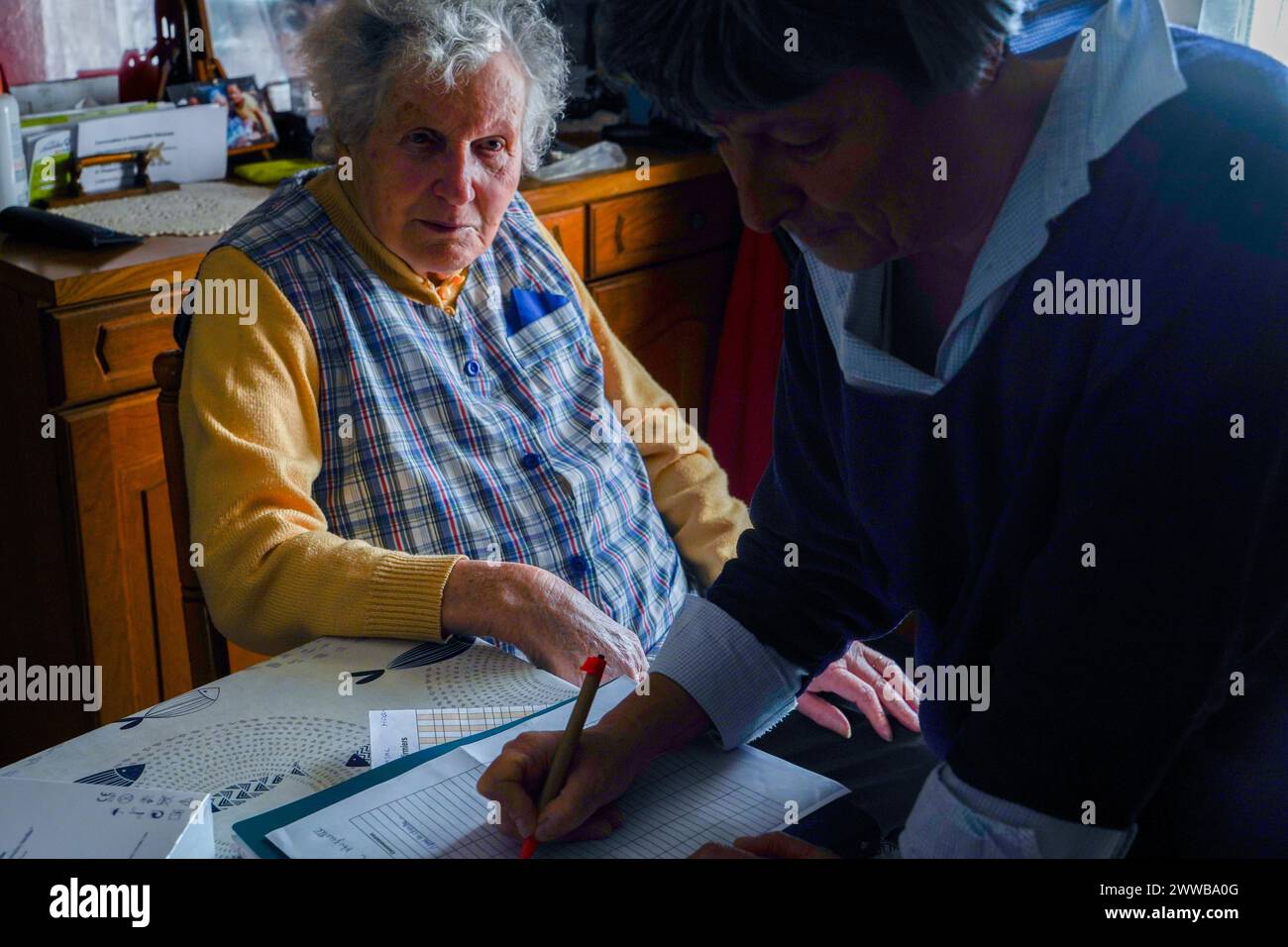 Infermiera freelance durante la sua visita quotidiana ad una persona anziana. Follow-up medici. Foto Stock