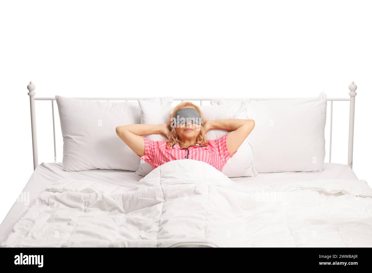 Donna che riposa in un letto con maschera sugli occhi isolata su sfondo bianco Foto Stock