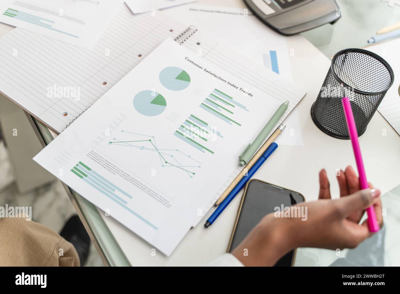 Primo piano su un rapporto aziendale dettagliato - donne afroamericane che analizzano le tendenze dell'indice di soddisfazione dei clienti, vari grafici e grafici in vista Foto Stock