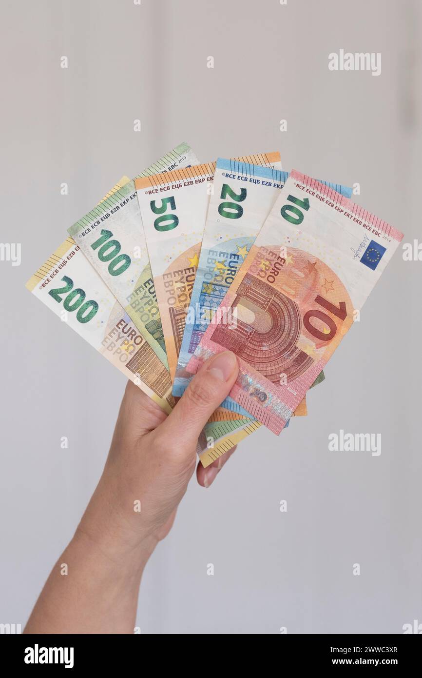 Mano che trattiene le banconote in euro Foto Stock
