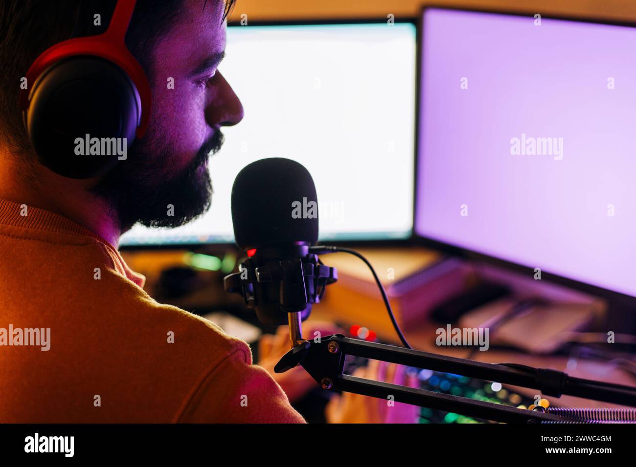 Influencer del gaming che esegue lo streaming live e gioca ai videogame su computer a casa Foto Stock