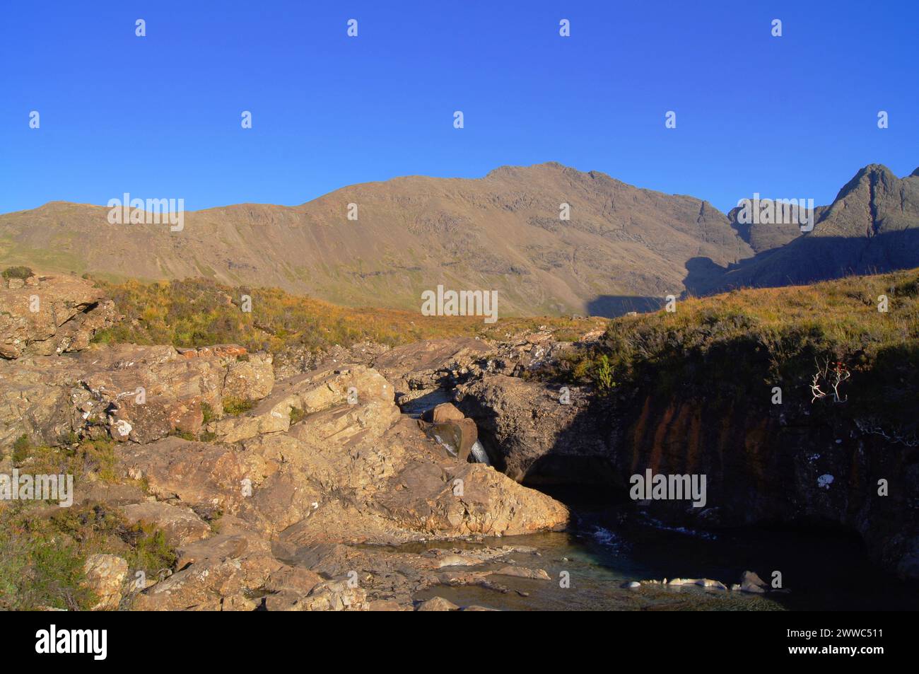 Le Fairy Pools sulla Allt Coire A' Mhadaidh (Burn of the Dog) con la catena di Black Cuillin, Isola di Skye, Scozia, Regno Unito Foto Stock