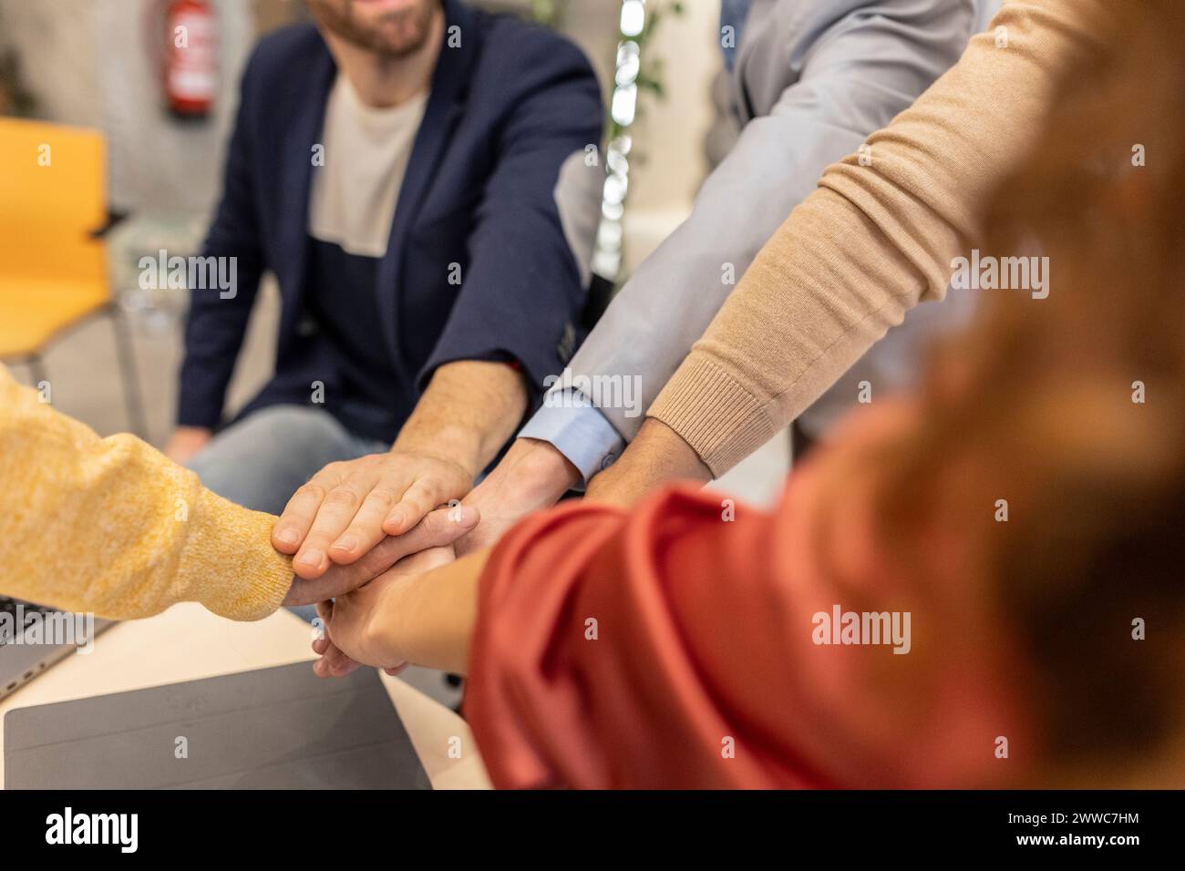 Colleghi di lavoro che si mettono le mani sul posto di lavoro Foto Stock