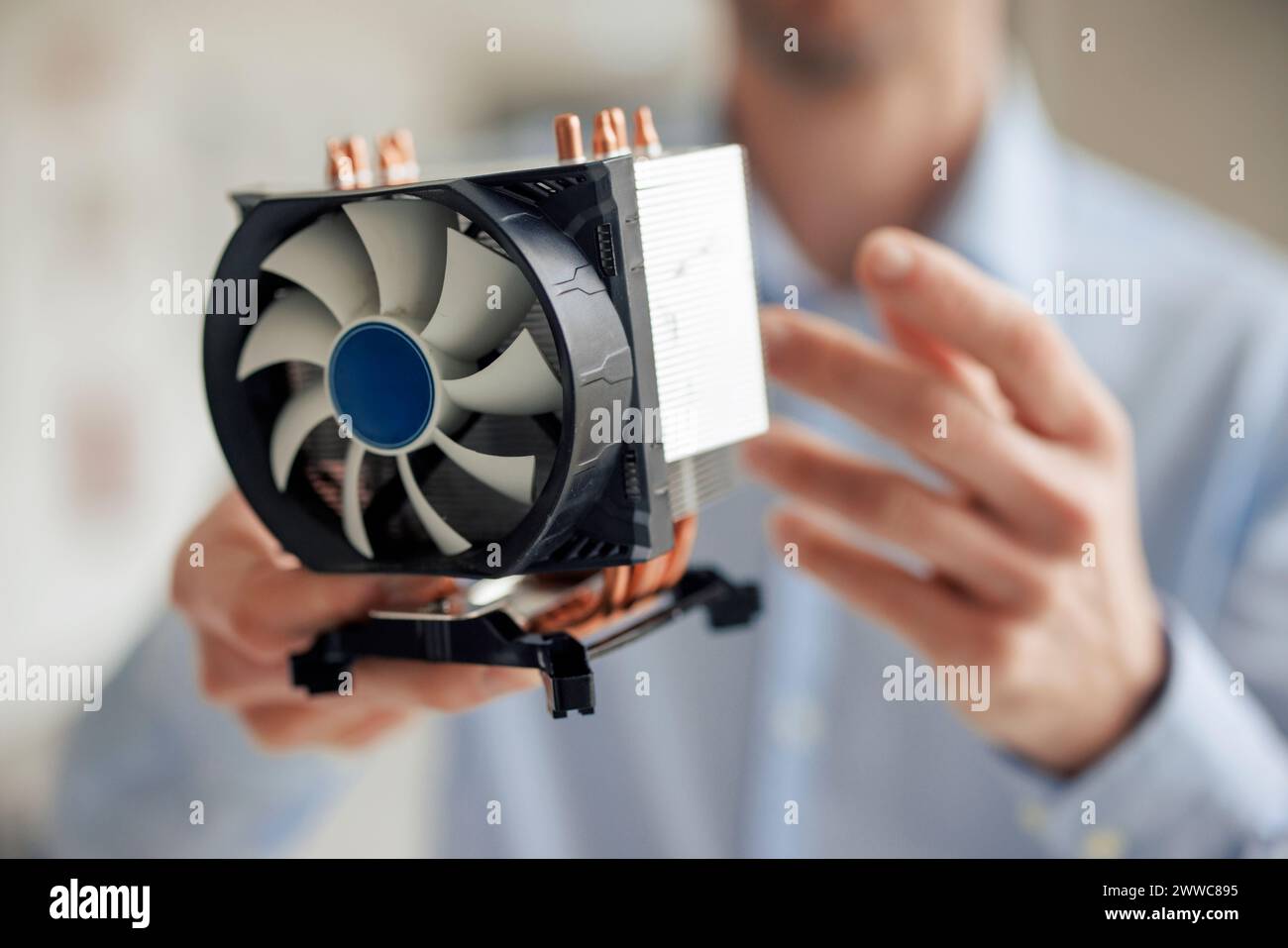 Ingegnere che tiene la ventola della CPU in officina Foto Stock