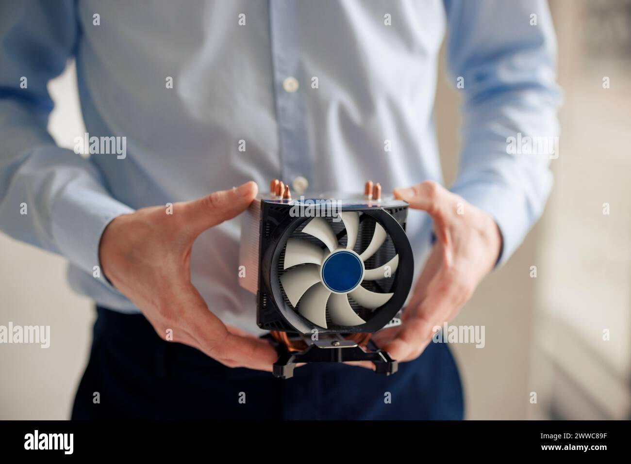 Ingegnere maturo che tiene la ventola della CPU in officina Foto Stock