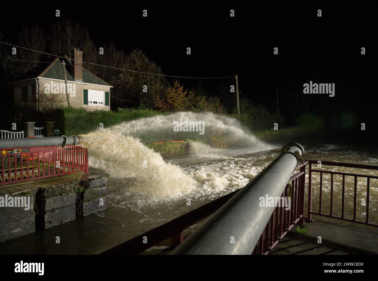 Francia, Hauts-de-France, Calais, pompe che versano acqua dalla zona allagata nel canale di notte Foto Stock