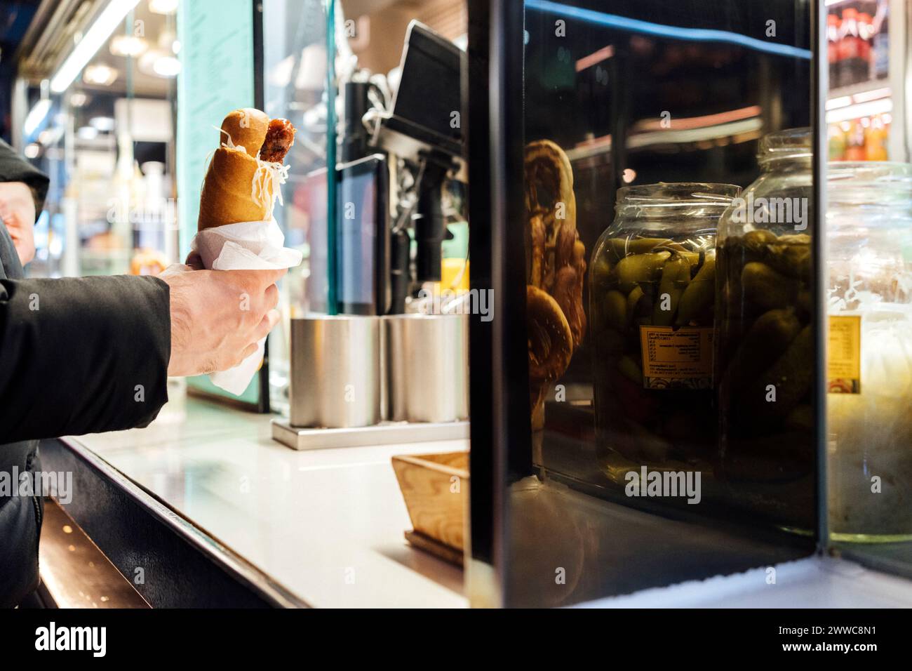 Un giovane uomo d'affari che compra hot dog dallo stand Foto Stock