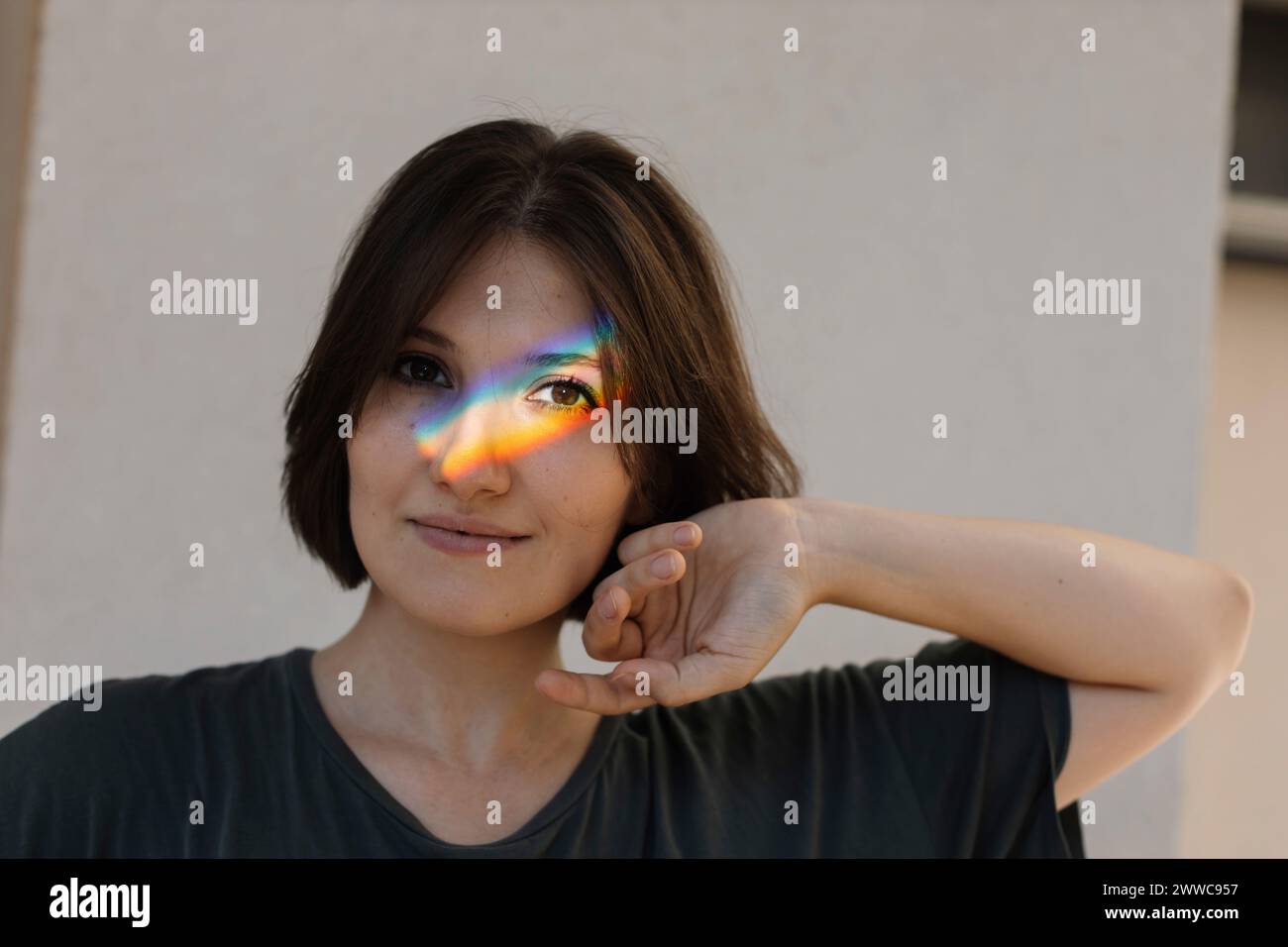 Luce colorata arcobaleno sul viso della donna Foto Stock