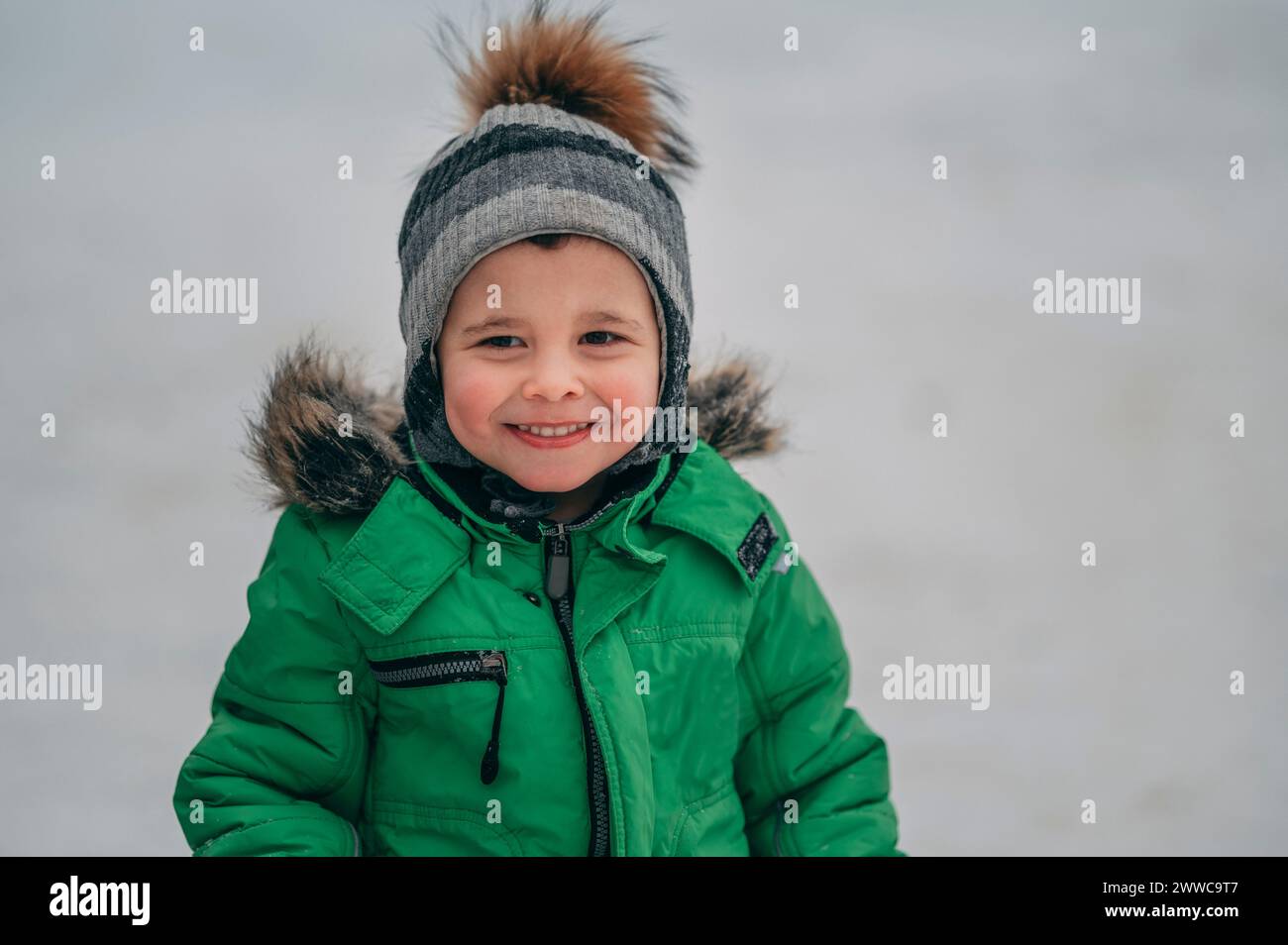 Ragazzo sorridente che indossa abiti caldi in inverno Foto Stock