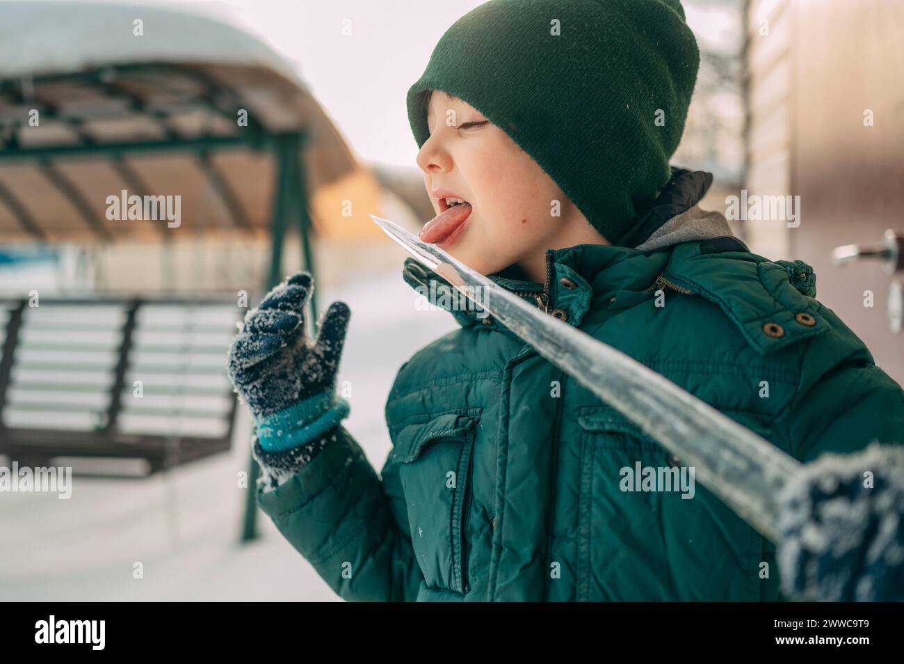 Ragazzo malizioso che lecca icicle in inverno Foto Stock