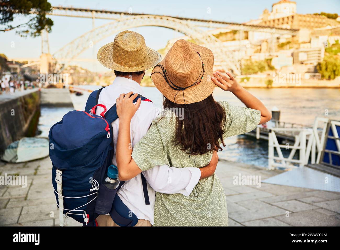 Giovane coppia che indossa un cappello e si trova di fronte al ponte Dom Luis a Porto, Portogallo Foto Stock Giovane coppia che indossa un cappello e si trova di fronte al ponte Dom Luis a Porto, Portogallo Foto Stock