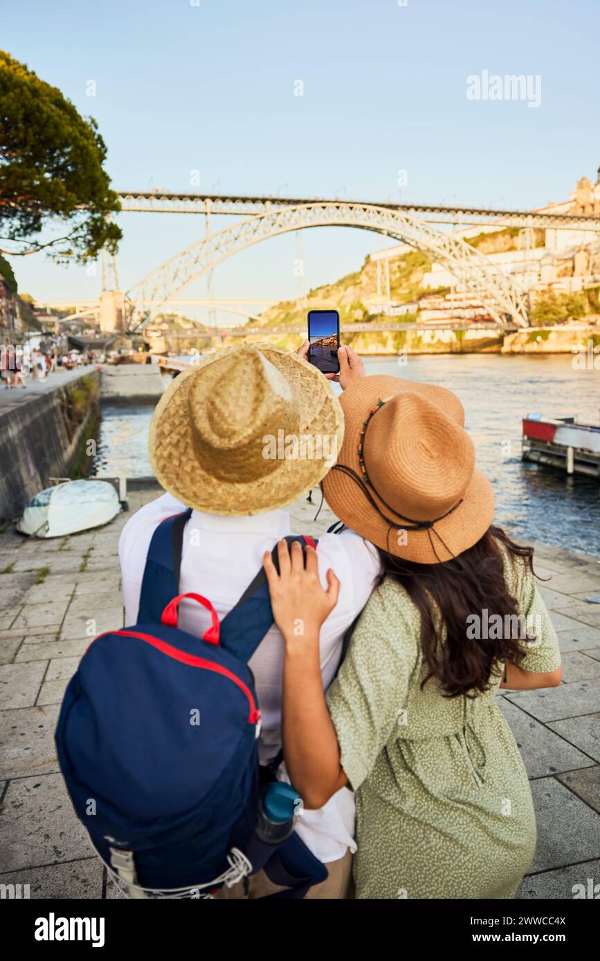 Giovane coppia che fotografa il ponte Dom Luis tramite smartphone a Porto, Portogallo Foto Stock Giovane coppia che fotografa il ponte Dom Luis tramite smartphone a Porto, Portogallo Foto Stock