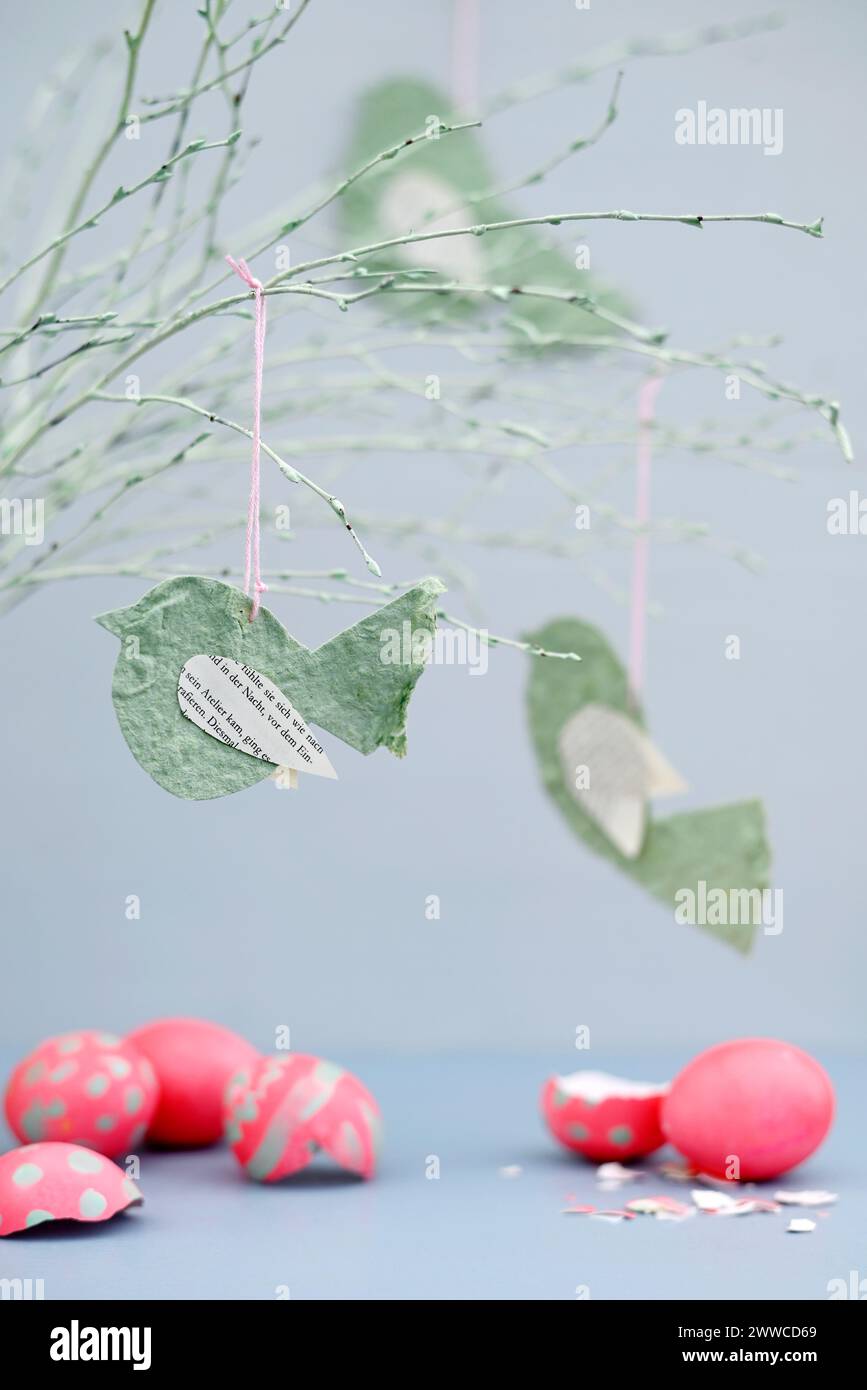 Uova di Pasqua e ramoscelli incrinati decorati con uccelli di carta Foto Stock