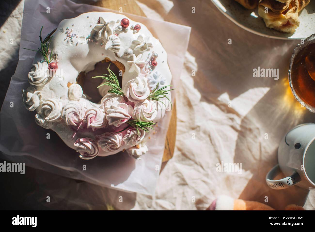 Torta fresca decorata con panna montata tenuta sul tavolo a casa Foto Stock