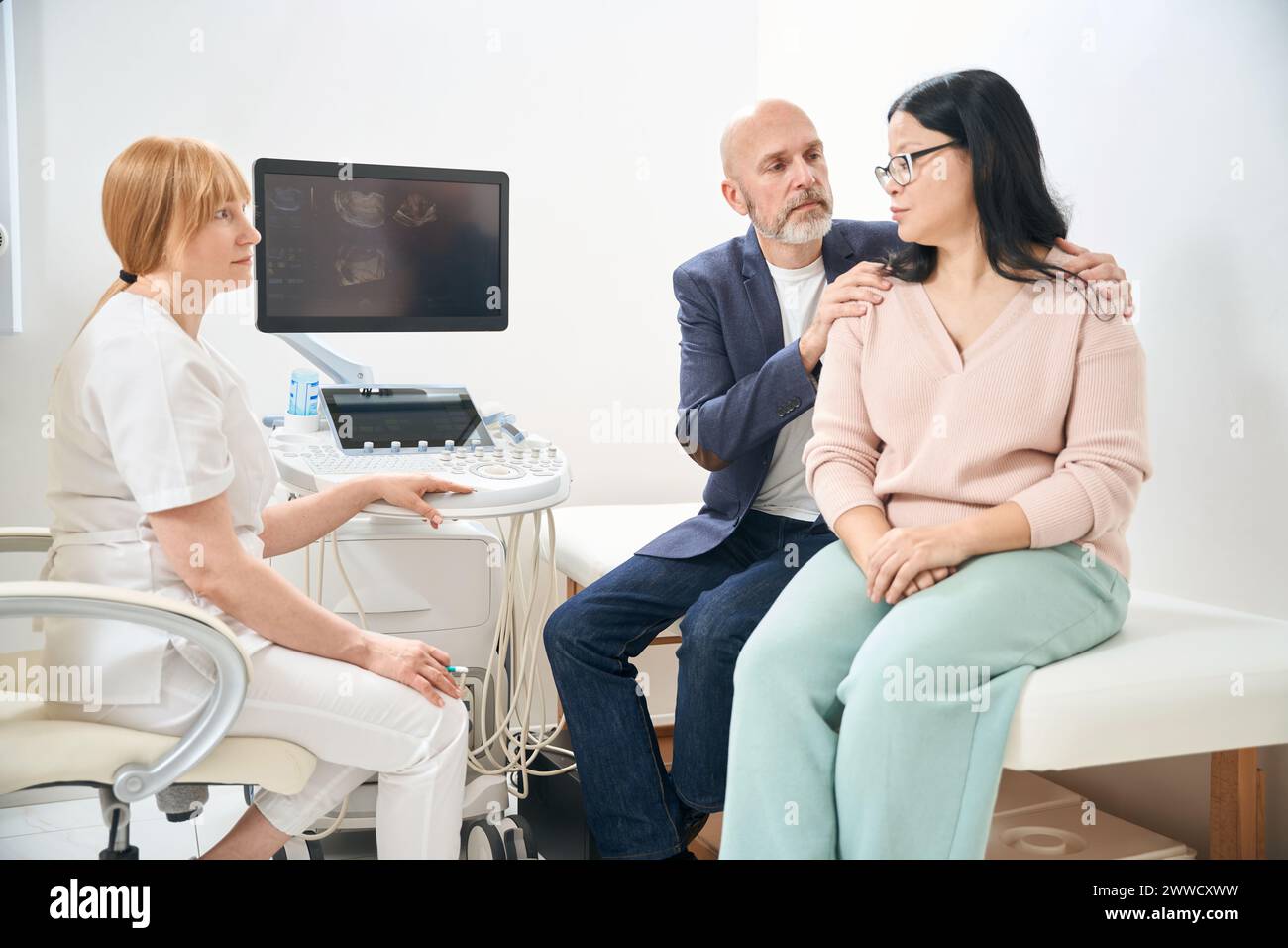 Ecografa donna che riporta cattive notizie sui difetti congeniti del feto Foto Stock