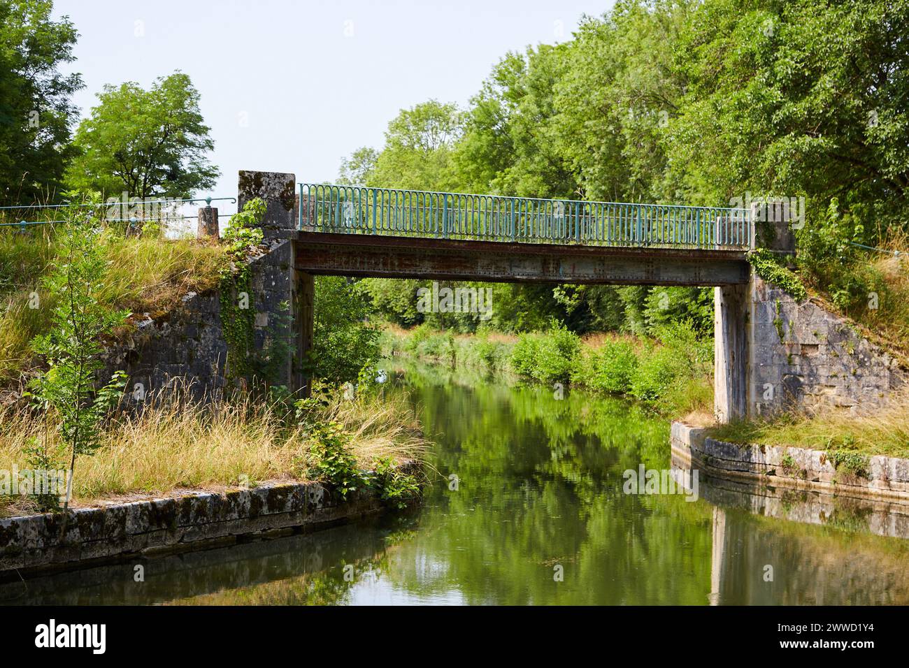 Stretto ponte su un fiume calmo Foto Stock