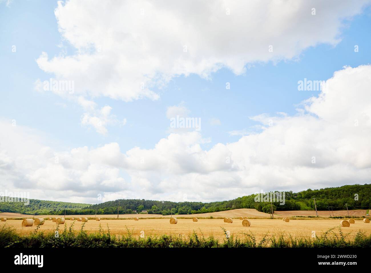 Cielo drammatico e nuvole con rotoli di fieno sul paesaggio Foto Stock