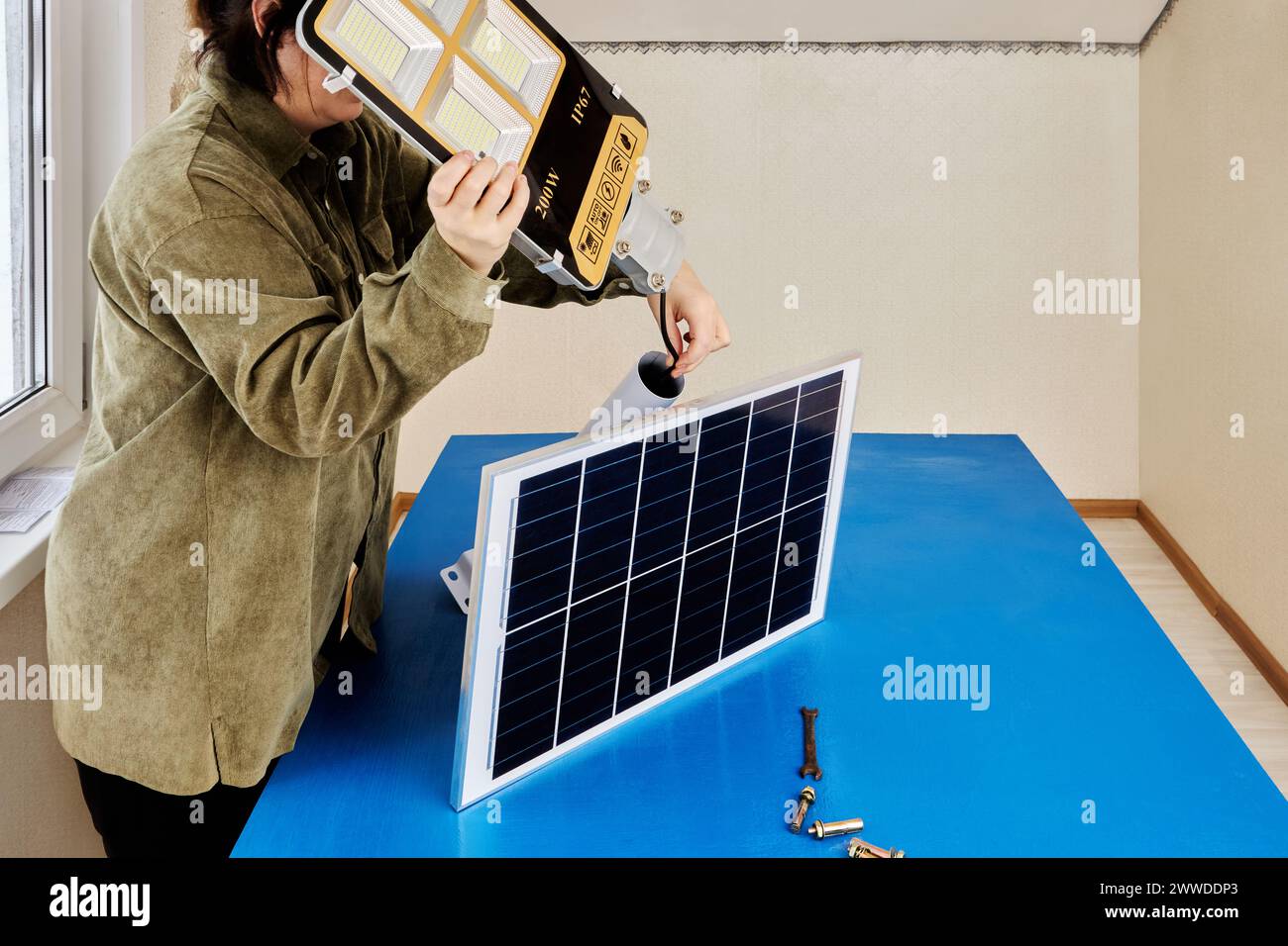 Montaggio di un lampione completamente autonomo sul tavolo di montaggio, fissaggio del modulo solare e della lampada a LED alla staffa di montaggio. Foto Stock