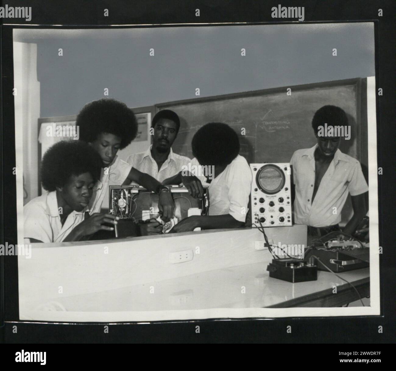 Gli studenti di una classe di elettronica alla B.V.I. High School di Road Town, Tortola, sono impegnati in lavori pratici con circuiti e attrezzature, illustrando 1975 pratiche educative. Foto Stock