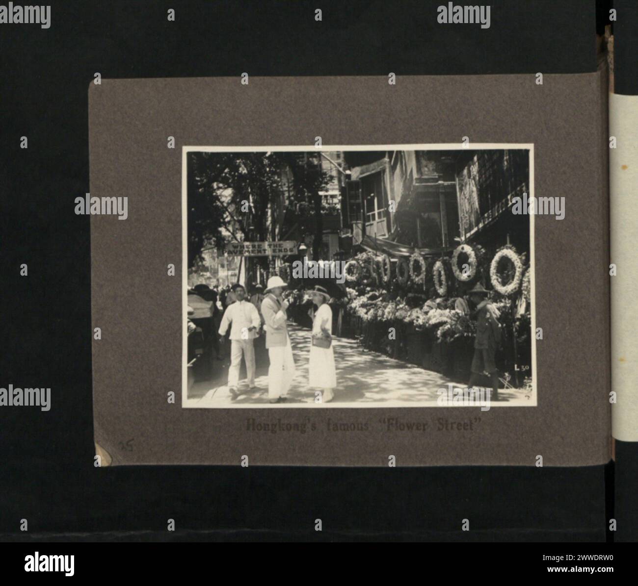 Questa immagine mostra la Flower Street di Hong Kong nel periodo 1920-1930, nota per i suoi mercati di fiori, i venditori ambulanti e l'attività del mercato urbano. Foto Stock