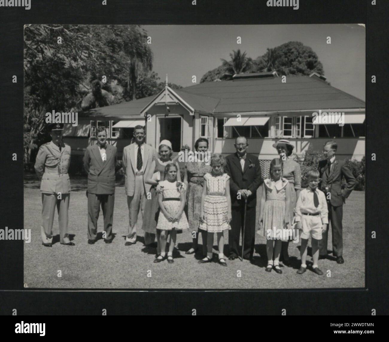 Descrizione: Un gruppo informale presso la residenza del console e agente britannico a Tonga. Fila posteriore, da sinistra a destra: Capitano del gruppo A.S. Agar, R.N.Z.A.F.; Mr. P.D. Macdonald, Segretario coloniale, Figi; sig. a.C. Reid, console e agente britannico; Miss Grania Grvey; Lady Garvey; Sir Ronald Garvey; Mrs. Reid; il figlio del signor e della signora Reid. Prima fila: Miss Julia Garvey; Miss Lavinia Garvey, e i figli di Mr. E Mrs. Reid. Ubicazione: Tonga tonga, australasia, oceania, australasiathrough alens Foto Stock