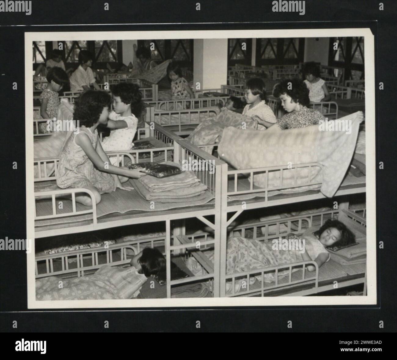 I campeggiatori a Silvermine Bay, Hong Kong, nel 1962 riposano dopo lunghe giornate di attività all'aperto, con chiacchiere minime dopo che le luci sono spente. Foto Stock