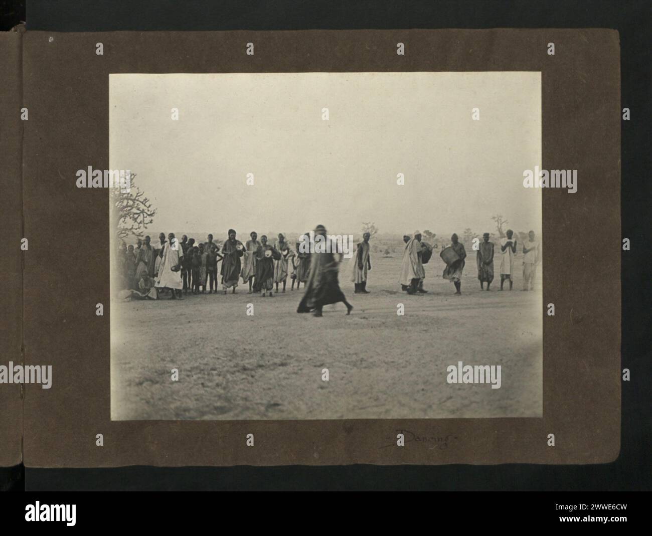 Immagine che mostra un ballerino nativo che si esibisce accompagnato da musicisti in Nigeria, intorno al 1920-1929, mettendo in evidenza la danza tradizionale e gli strumenti musicali. Foto Stock